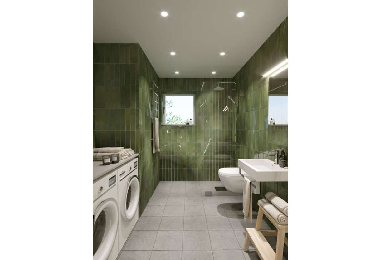 Helkaklat badrum, gröna glaserade plattor på vägg. Golvplattor i granitkeramik i kalkstenstextur.